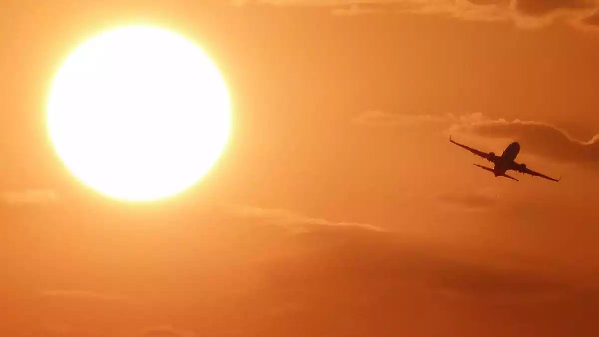 Imatge d'un avió creuant el cel en un dia de forta calor a Catalunya