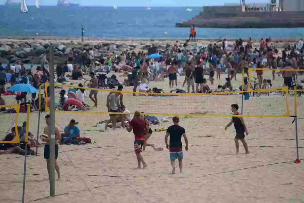 Pla general d'un grup de joves juga al voleivol a la platja del Bogatell de Barcelona