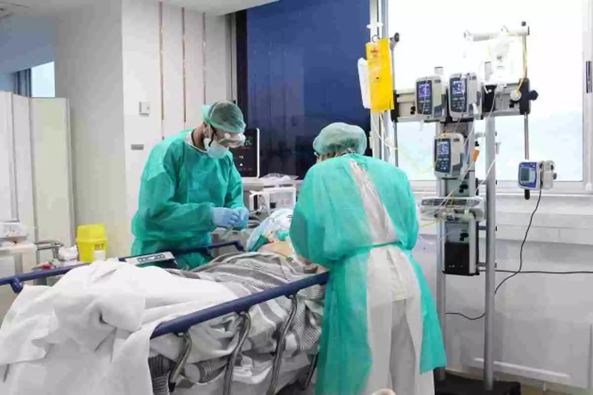 Imatge  de dos metges tenint cura d'un pacient amb coronavirus a l'hospital Trueta de Girona
