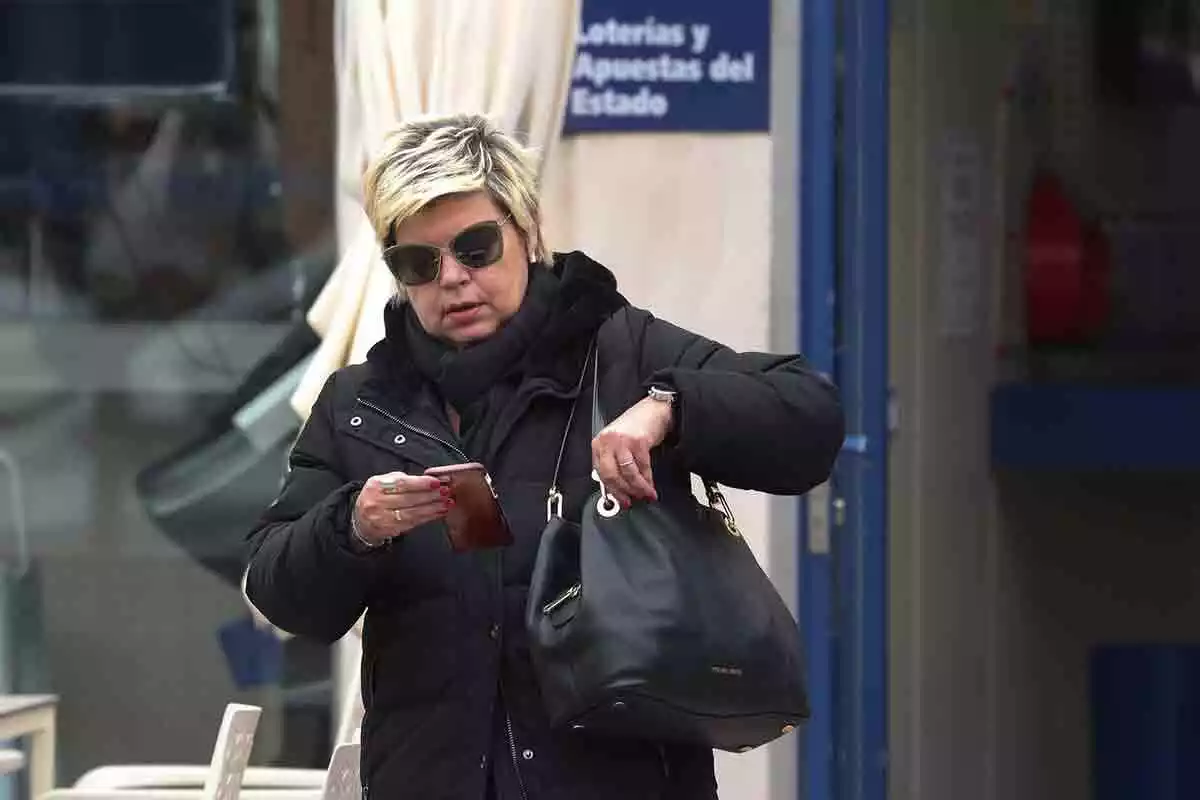 Terelu Campos por la calle mirando su teléfono móbil
