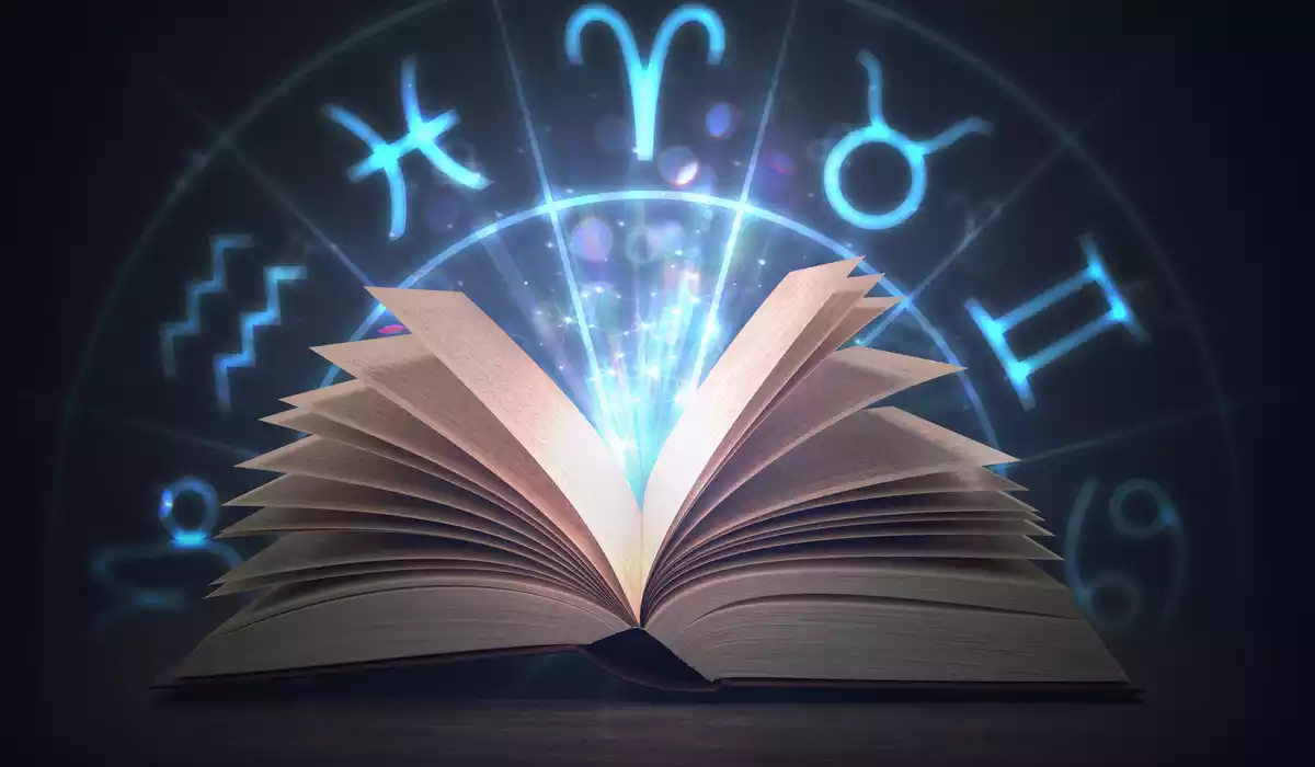 Algunos signos del zodiaco en azul con un libro abierto delante