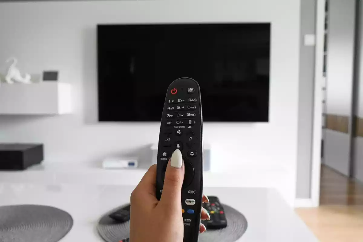Una mano sostiene un mando de televisión.