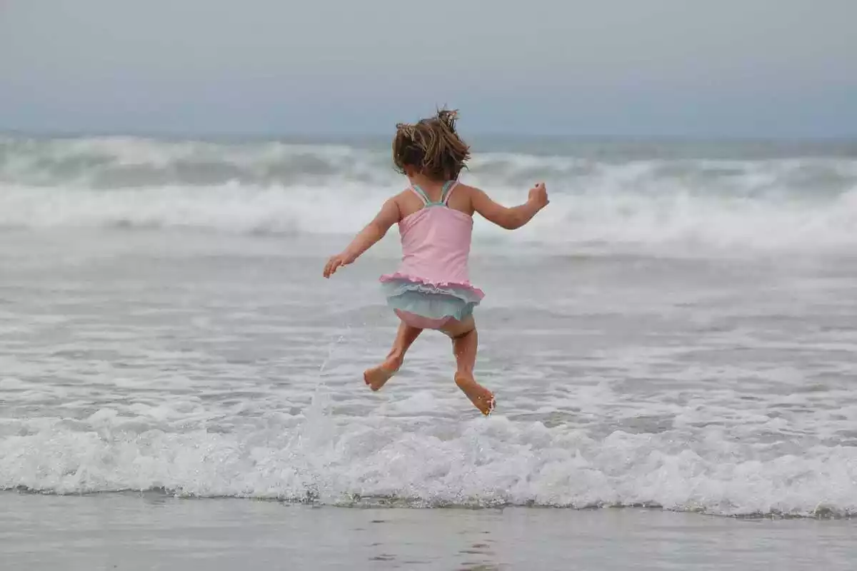 Una niña entrando en el mar
