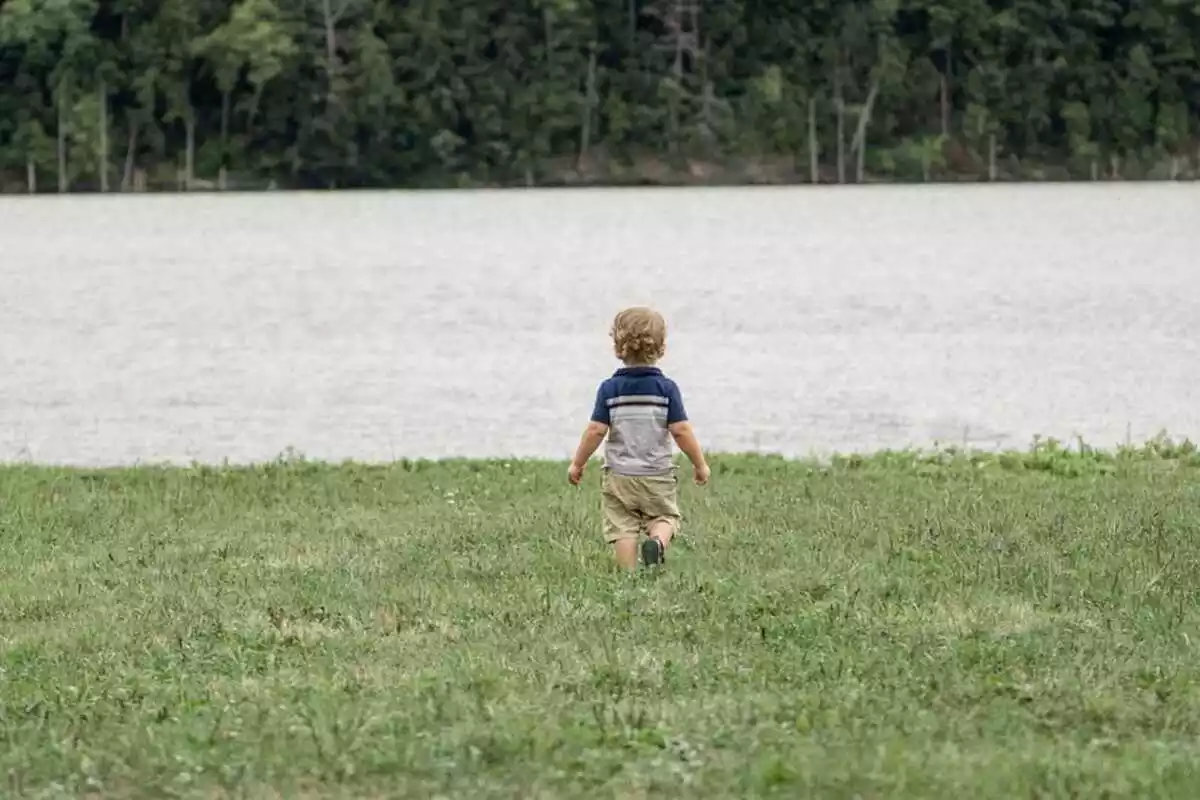 Un niño pequeño junto a un río