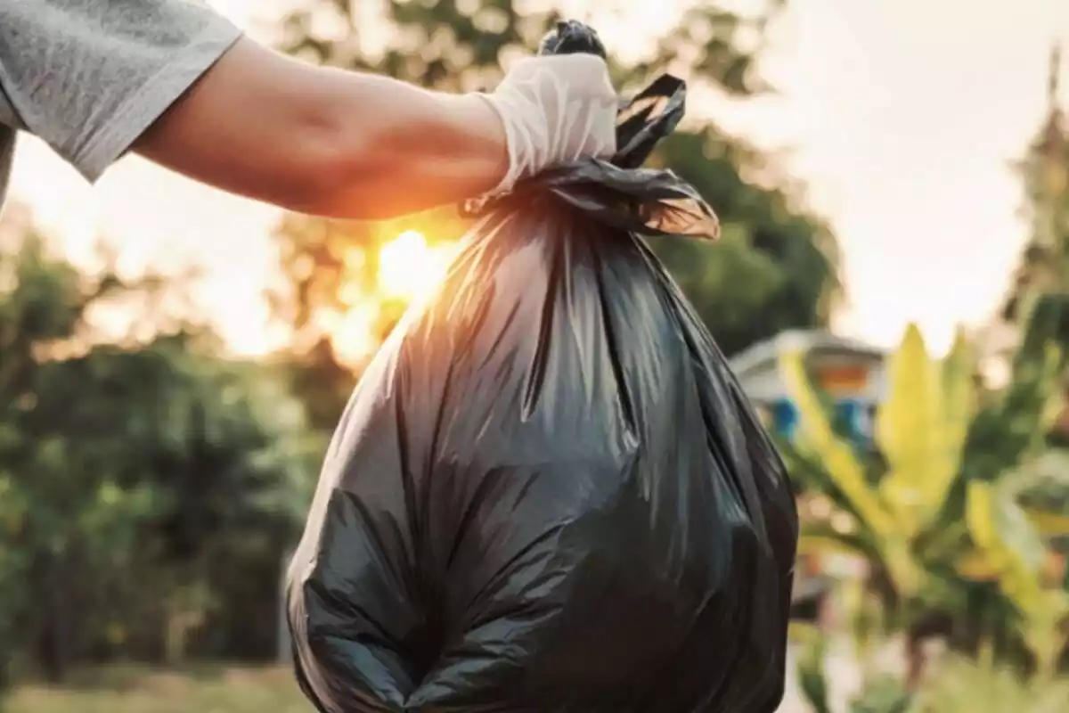 Detalle de una mano llevando una bolsa de plástico