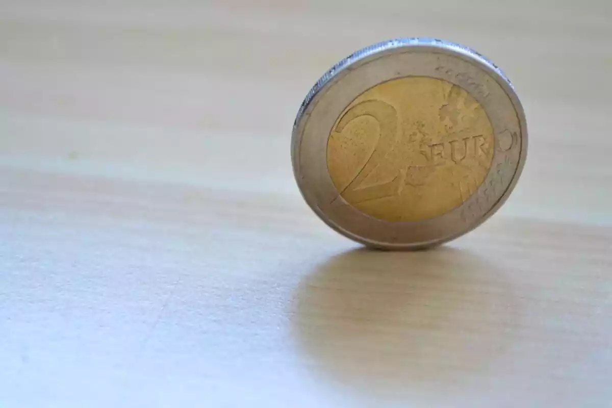 Imagen de una moneda de dos euros sobre una mesa