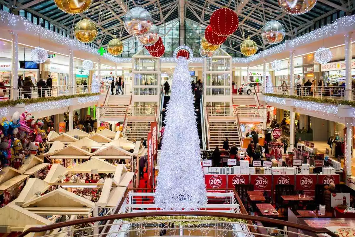 Un centro comercial lleno de gente y decoración navideña