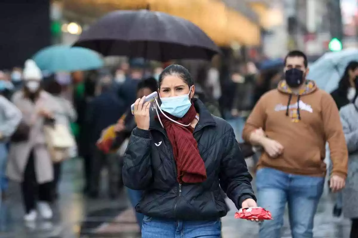 Una mujer pasea con mascarilla por Madrid