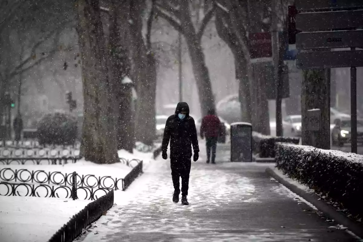 Una persona andando sola por la calle durante la borrasca Filomena, en Madrid