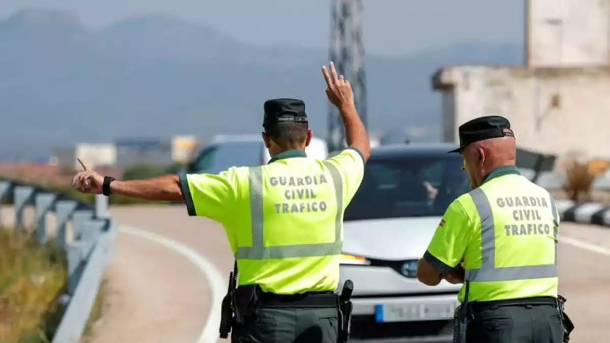 Dos guardias civiles paran a un coche que está circulando