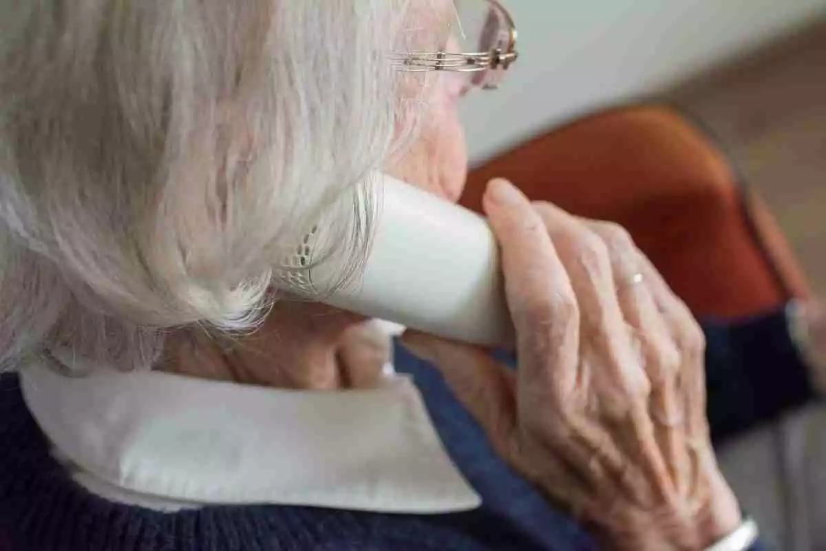 Persona mayor sosteniendo el teléfono en su oreja