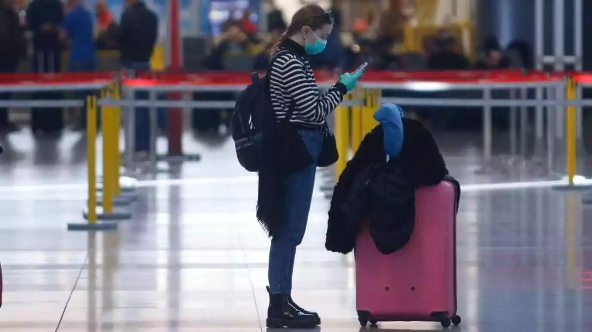 Una turista con mascarilla y guantes en el aeropuerto de Málaga.