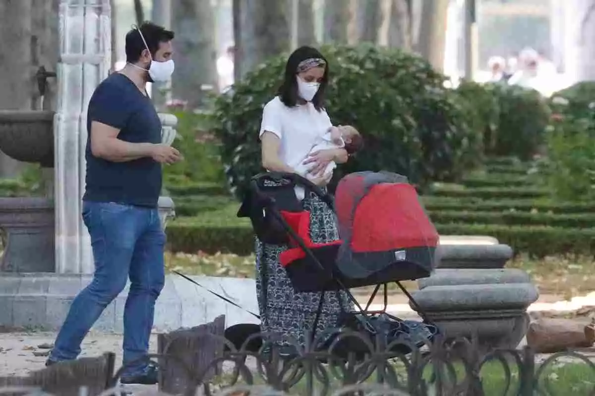 Inés Arrimadas con su hijo en brazos en la calle ante la mirada de su marido, Xavier Cima