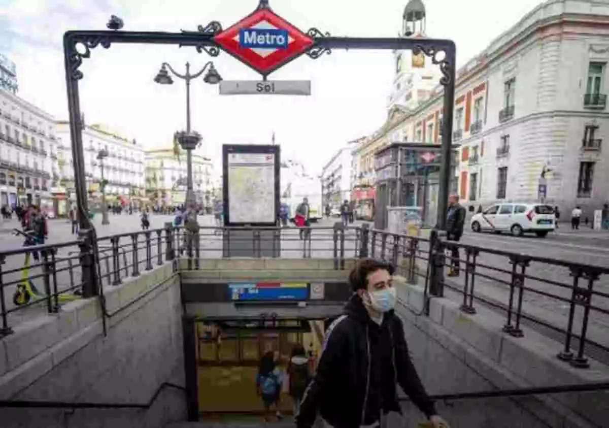 Imagen de una persona con mascarilla saliendo del metro en la parada Sol de Madrid