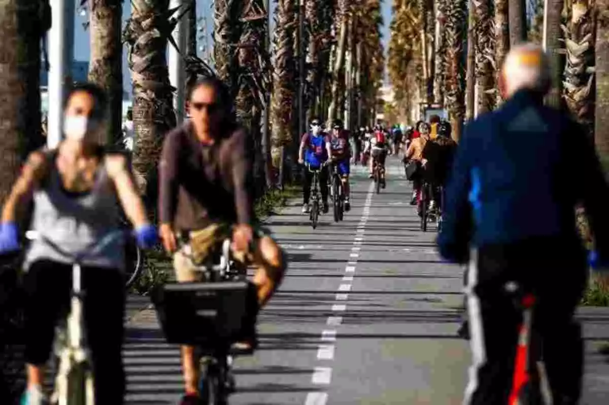 Ciudadanos paseando en bicicleta por el litoral en una ciudad de España