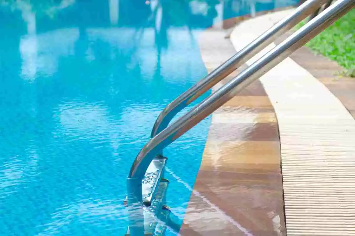 Unas escaleras con barras laterales en una piscina