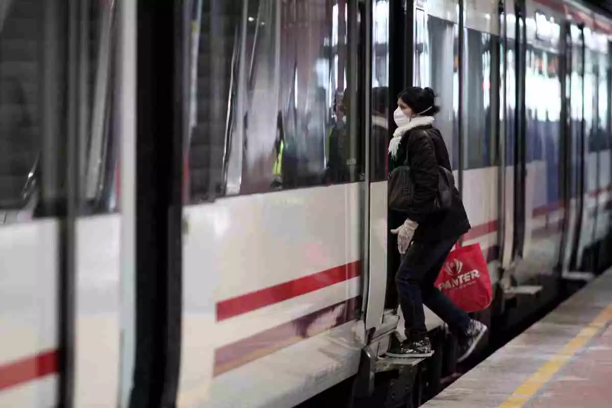 Viajeros con mascarillas subiendo a un tren en Atocha
