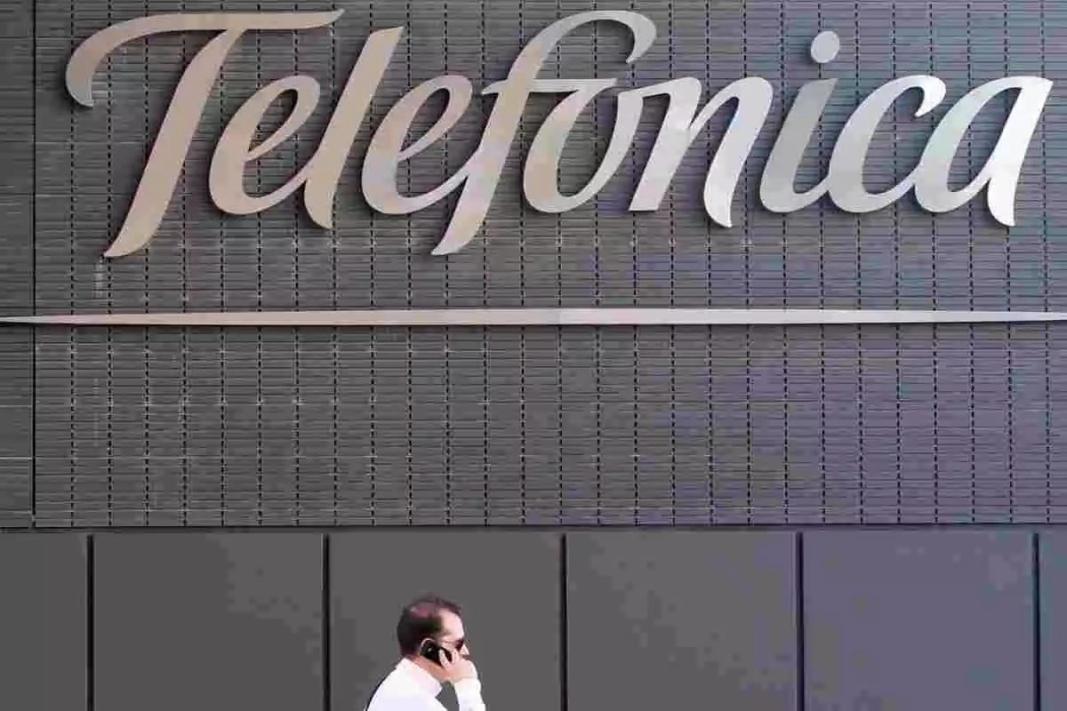 Un hombre habla por teléfono enfrente de la sede de Telefónica