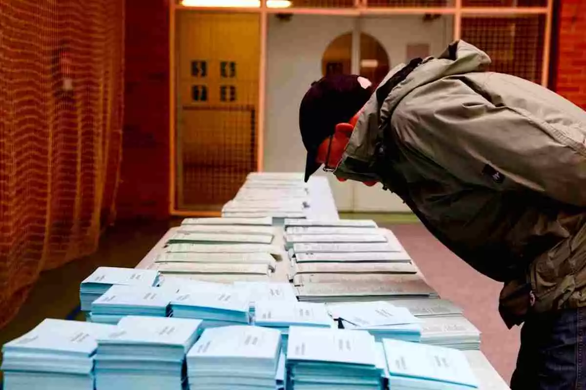 Un hombre escogiendo papeleta para votar