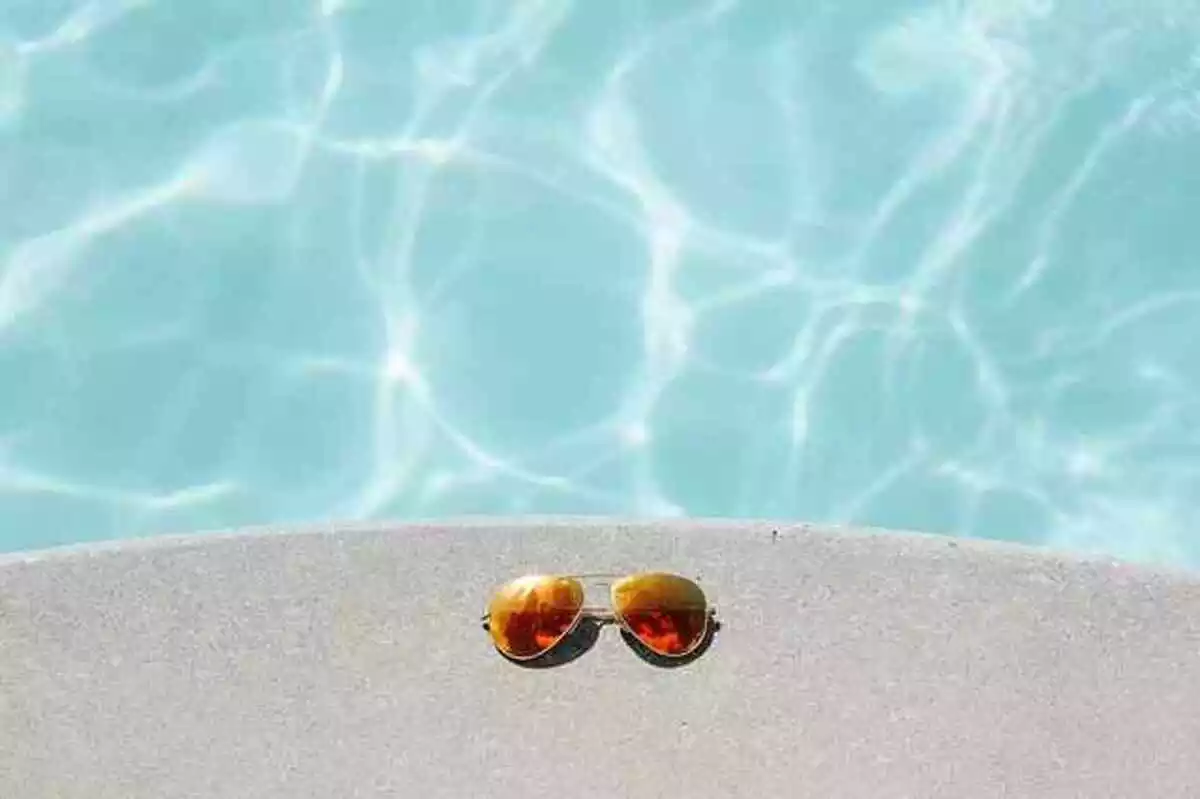 Gafas de sol al lado de una piscina