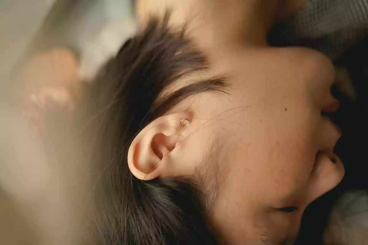 Fotografía de una oreja de una mujer durmiendo
