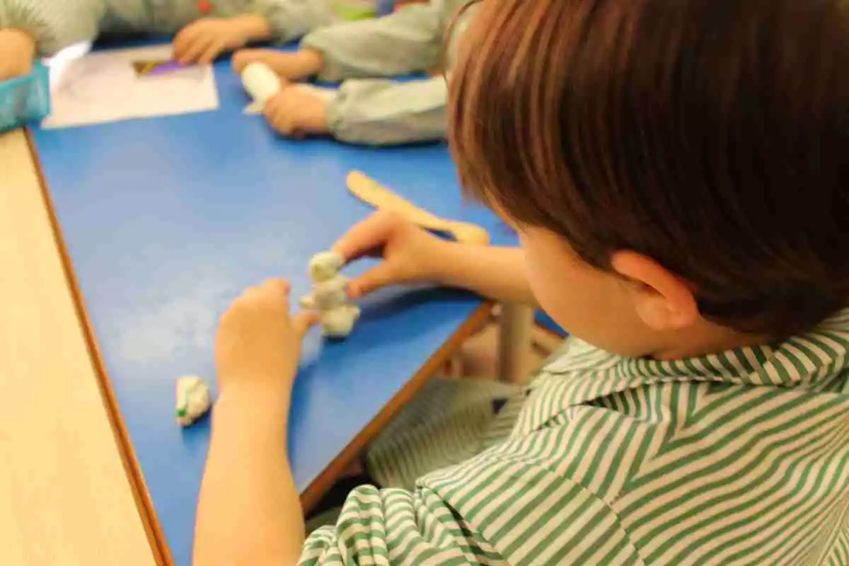 Niños jugando con plastilina en clase