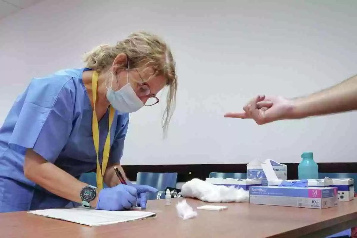 Una sanitaria toma una muestra de sangre de los test rápidos de Covid-19 que se realiza a los docentes en el Hospital Militar de Sevilla, 28 de agosto del 2020