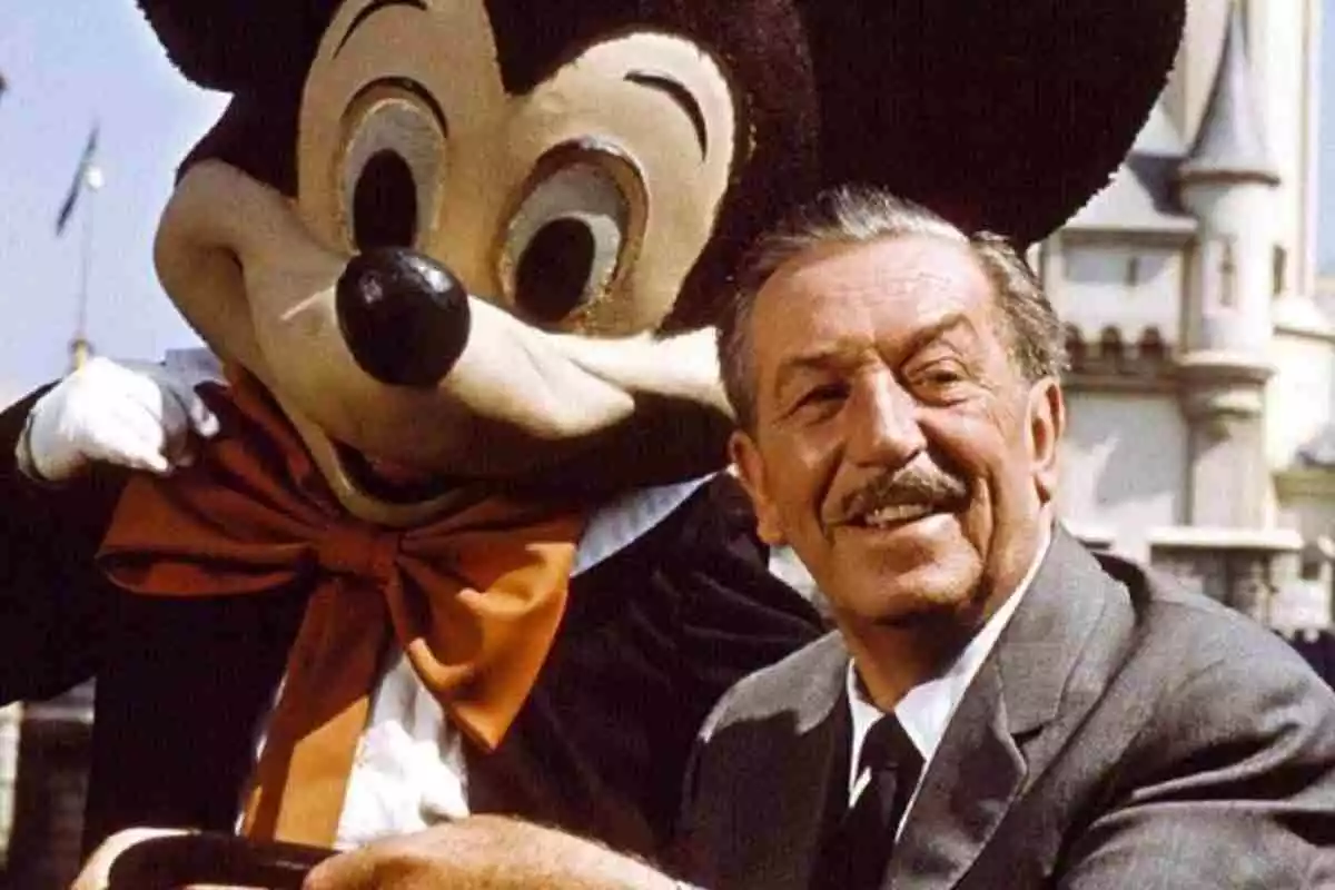 Walt Disney junto a una persona disfrazada de Micky Mouse en uno de sus parques de atracciones