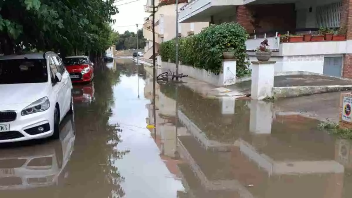 Calle inundada después de una intensa lluvia con coches aparcados