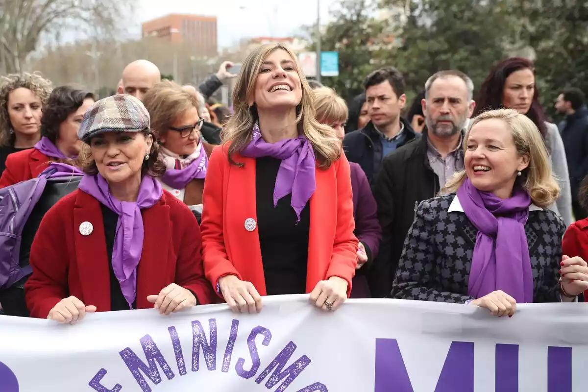 Carmen Calvo, Nadia Calviño y Begoña Gómez sujetando una pancarta feminista en la manifestación del 8-M