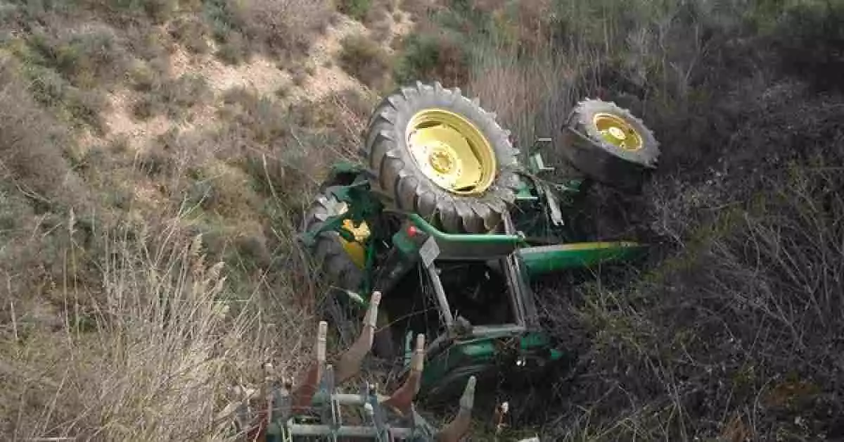 Imagen de un tractor accidentado al fondo de un barranco
