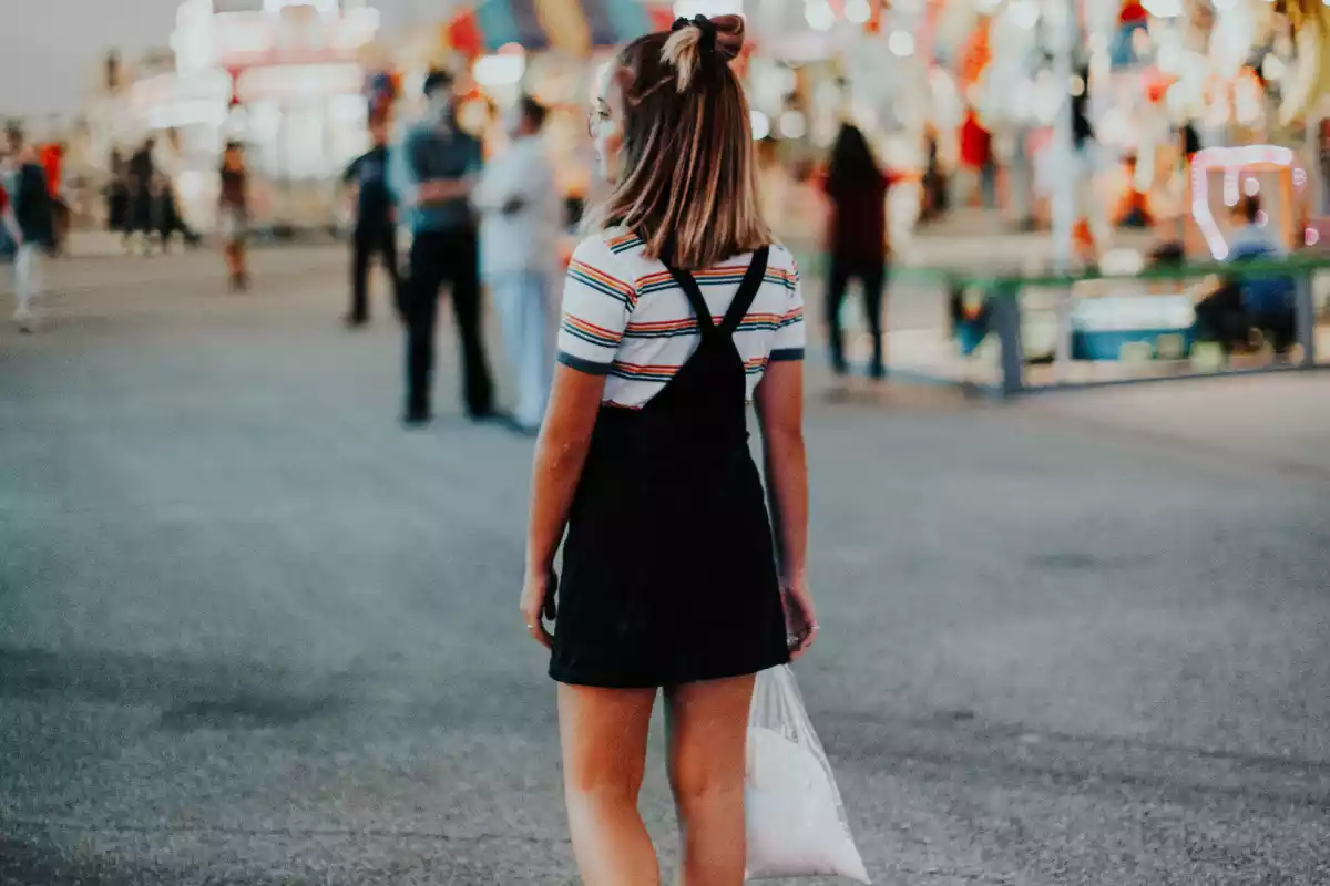 Imagen de una chica con un pichi negro en un parque de atracciones