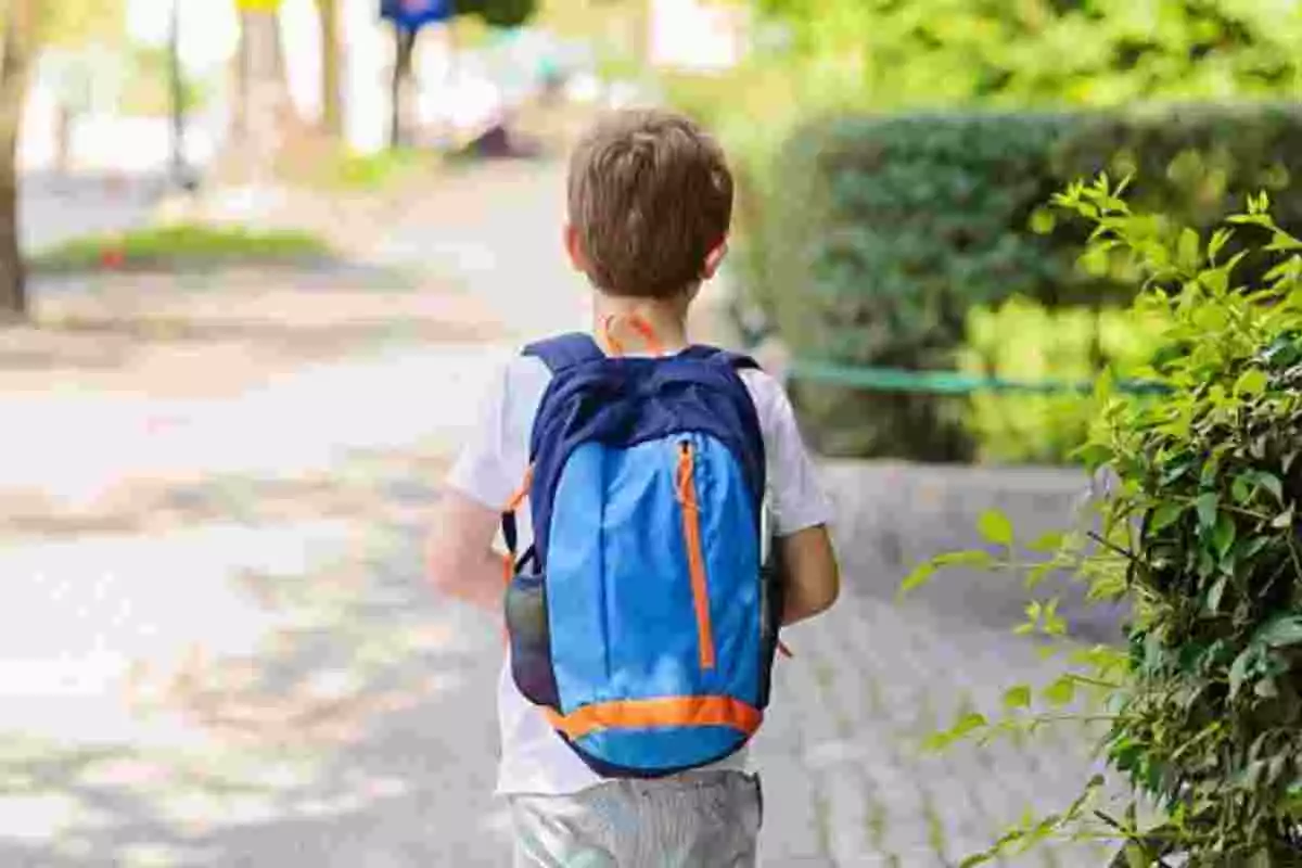 Niño de 6 años paseando por la calle con una mochila