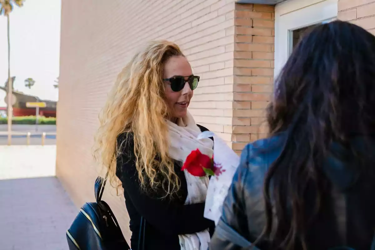 Rocío Carrasco sujetando una rosa en la calle