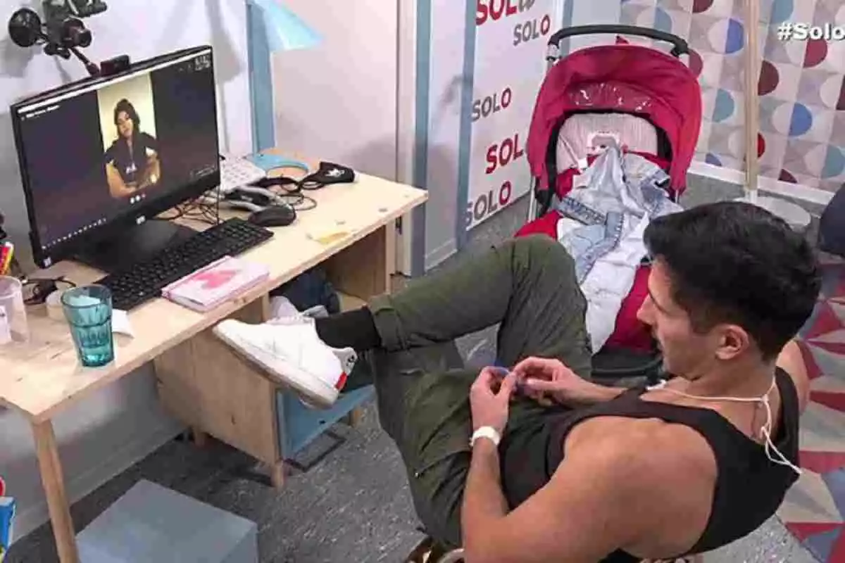 Gianmarco Onestini sentado en una silla en el reality 'Sola/Solo' teniendo una videollamada con Maite Galdeano