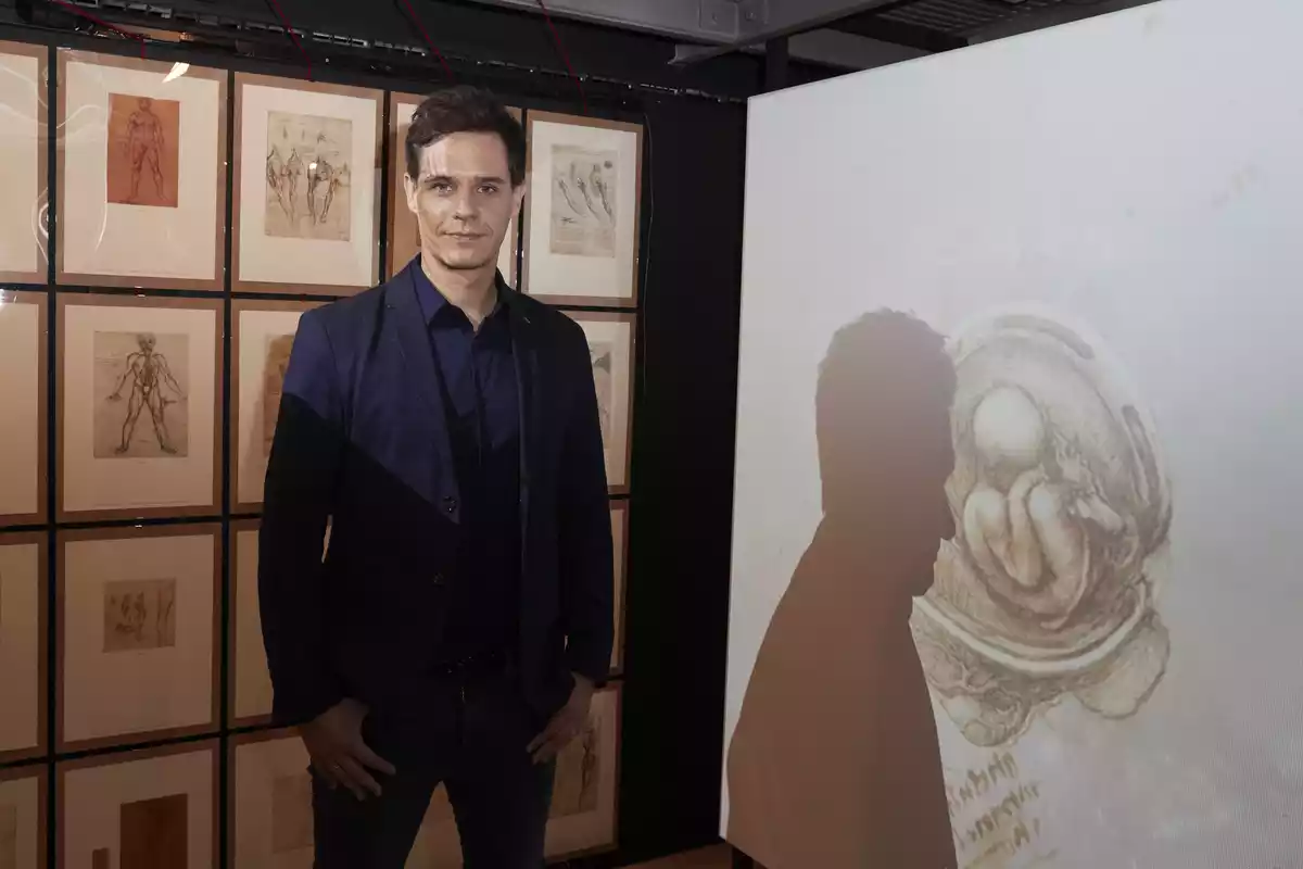 Christian Gálvez oisa frente a una colección de obras de arte