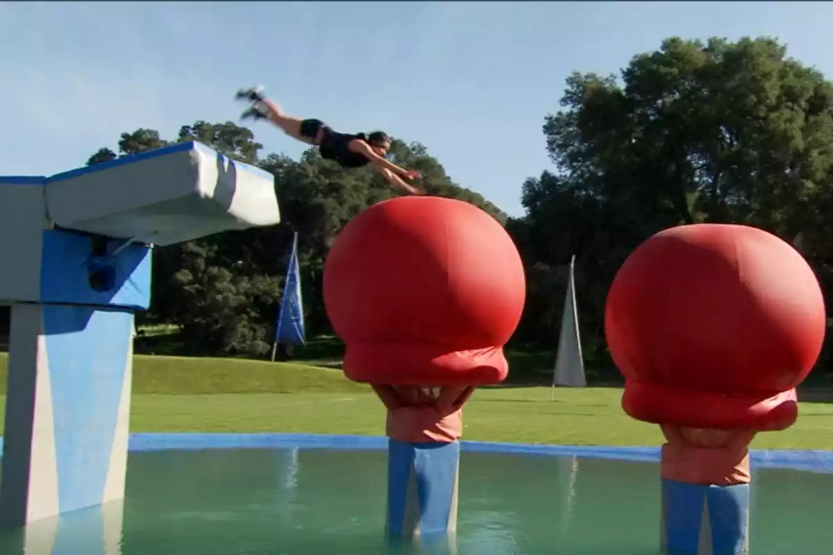 Concursante saltando hacia una gran bola durante una de las pruebas de 'Wipeout'
