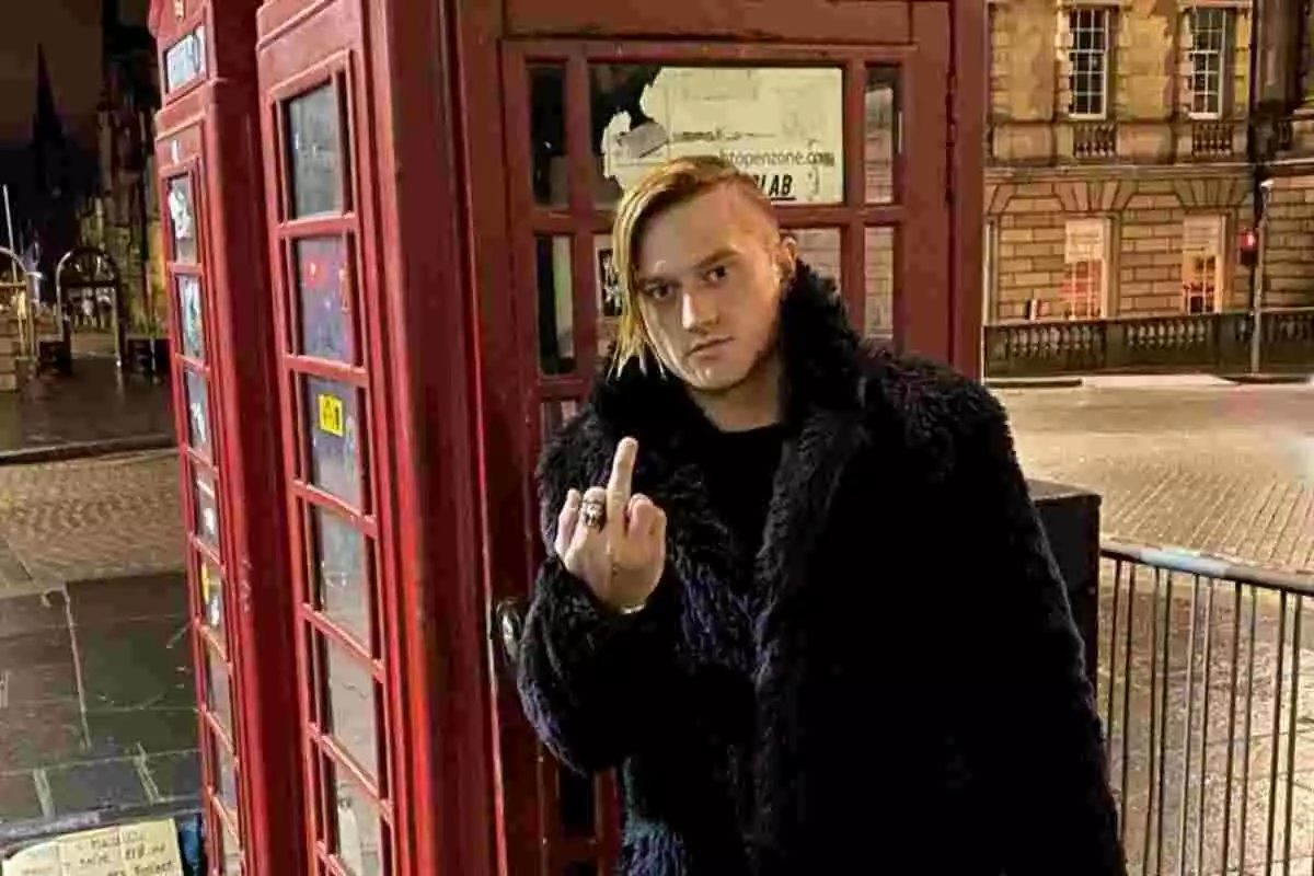 Eddie Hassell frente a una cabina telefónica