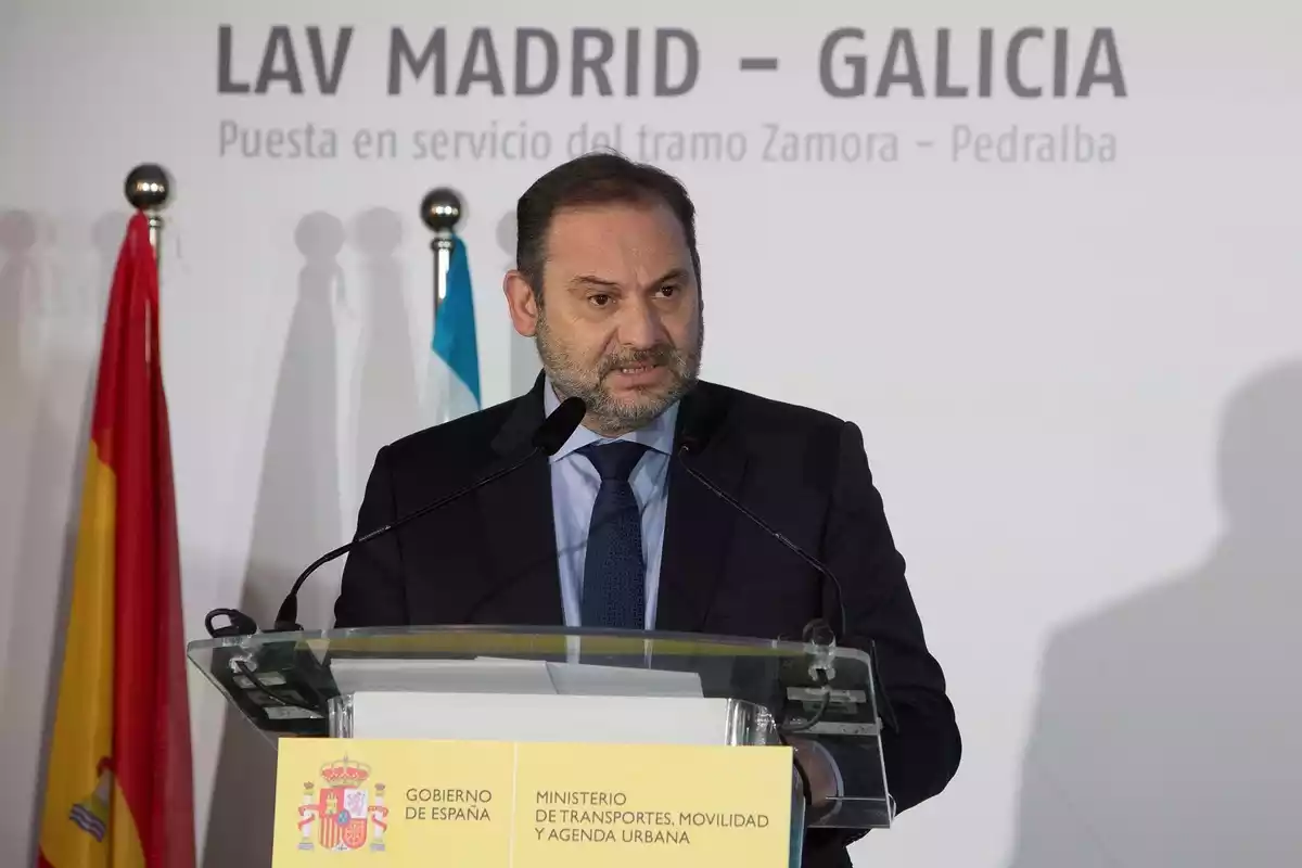 El ministro José Luis Ábalos dando un discurso en un atril con la bandera nacional de fondo