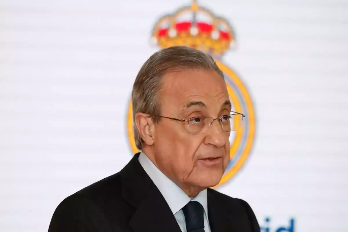 Florentino Pérez con un escudo del Real Madrid de fondo
