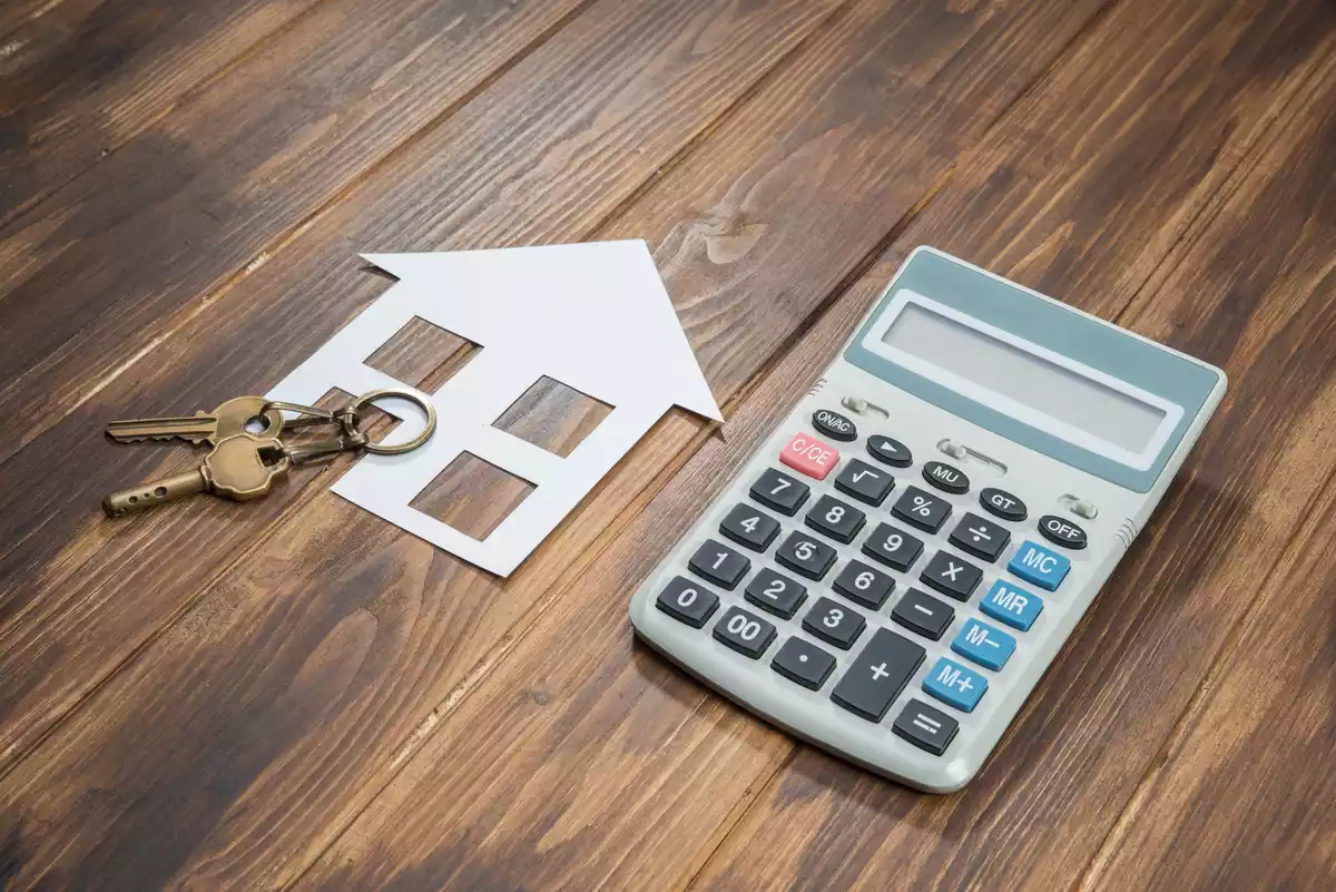 Fotografía de una calculadora y unas llaves de casa sobre una mesa