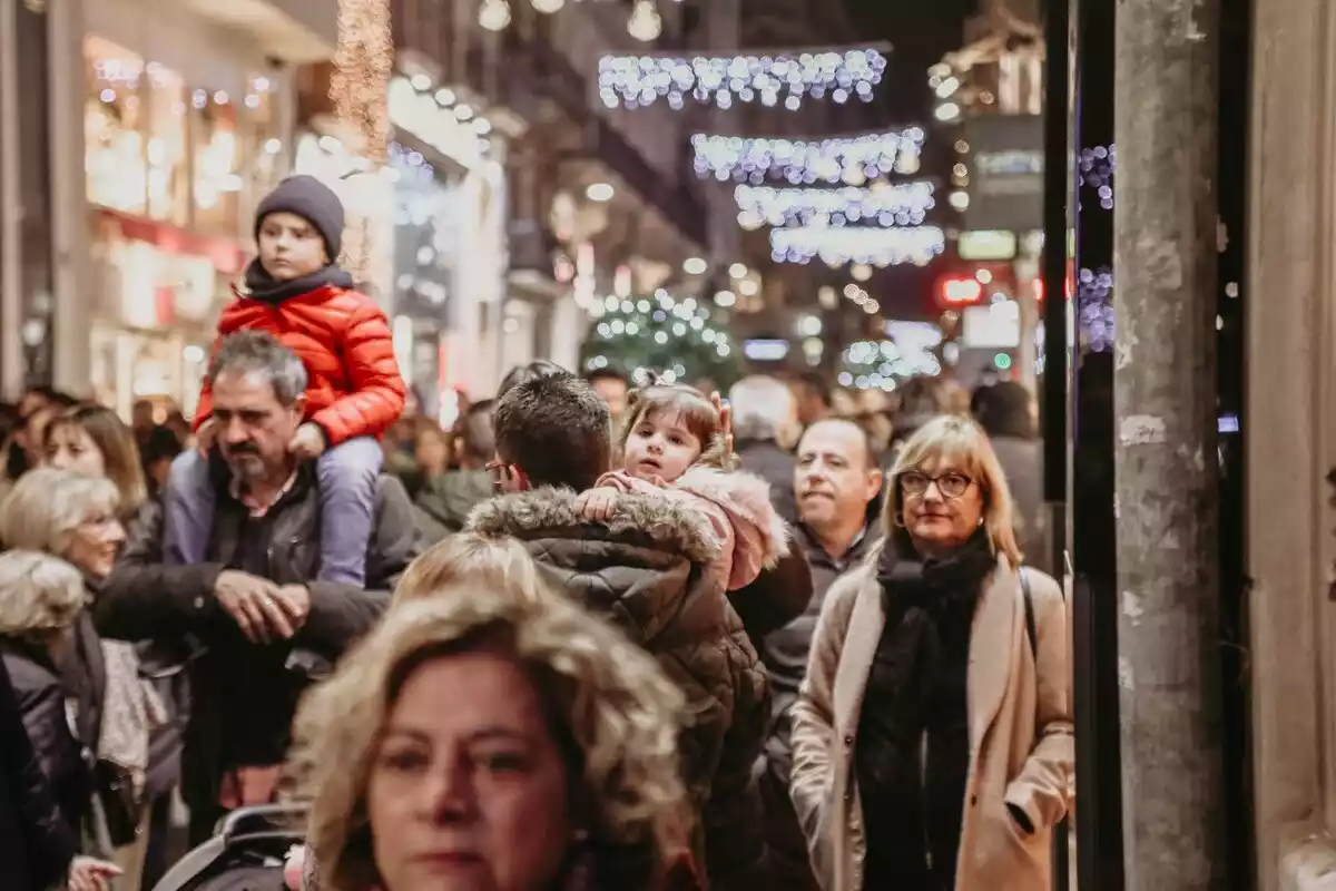Gente paseando por las calles decoradas con luces de navidad