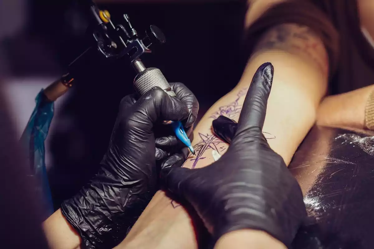 Imagen de archivo de un tatuador haciendo un tatuaje