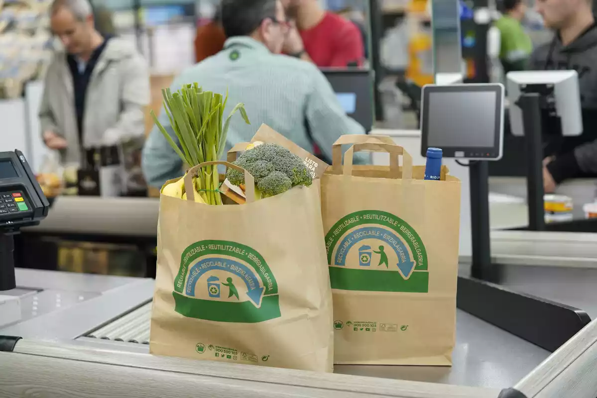 Imagen de dos bolsas de Mercadona en el lineal de cajas de un supermercado