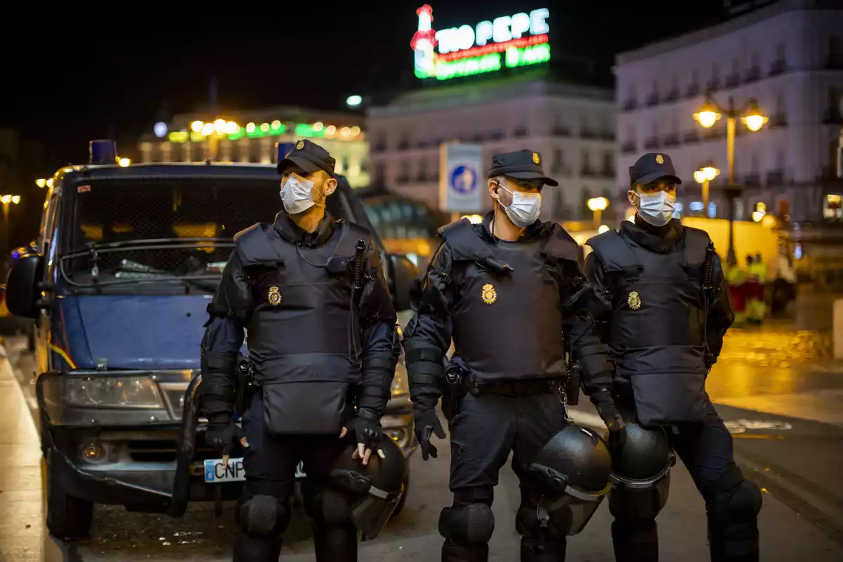 Miembros del cuerpo de antidisturbios de la Policia Nacional, con mascarilla puesta, por Madrid