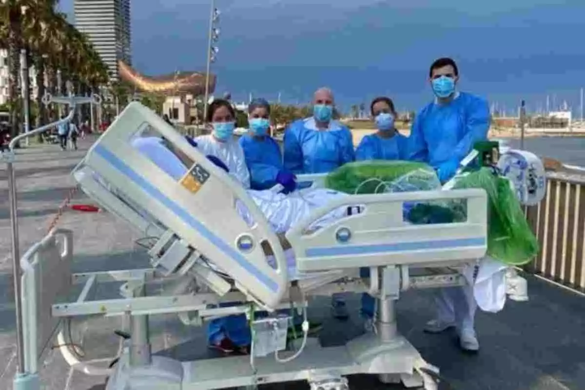 Paciente de Covid-19 en camilla frente al mar acompañado del equipo médico del Hospital del Mar de Barcelona