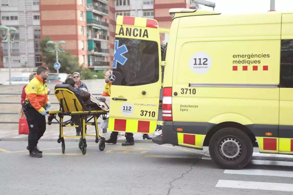 Sanitarios cargando un herido a una ambulancia