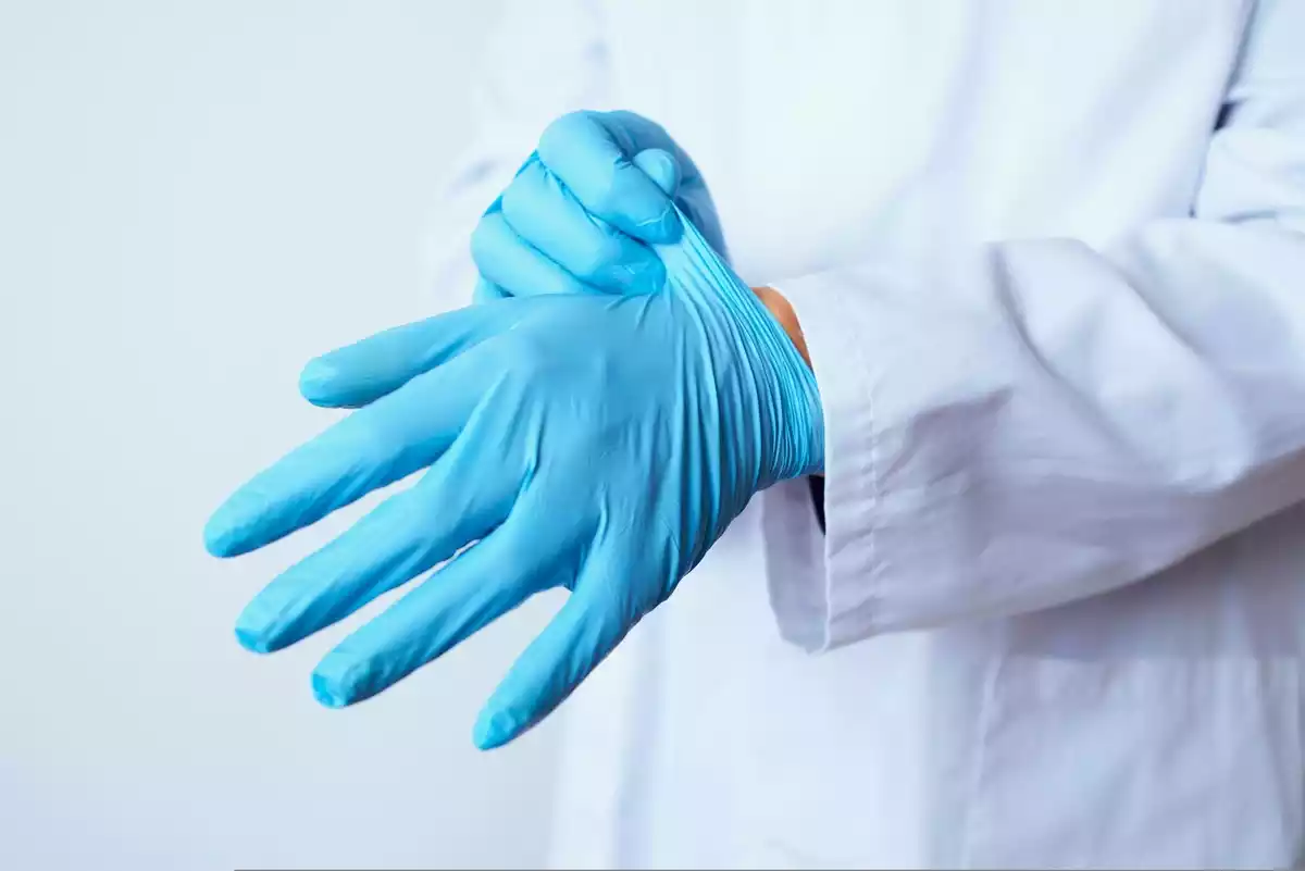 Un profesional sanitario colocándose unos guantes
