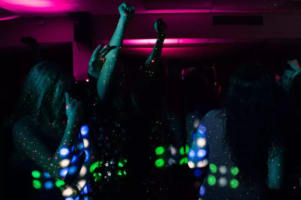 Varias personas en el interior de una discoteca bailando con escasa iluminación