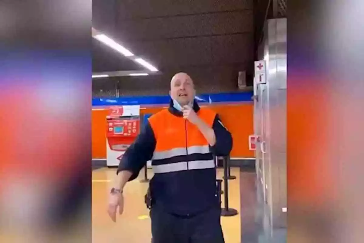Vigilante de seguridad del Metro de Madrid con la mascarilla bajada y encarándose a un joven